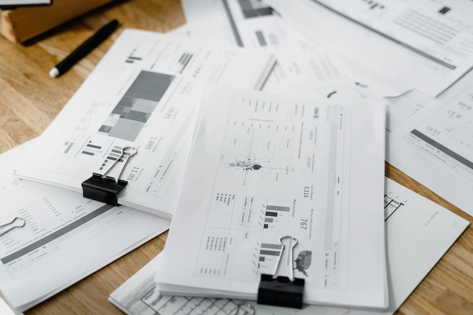 A stack of financial reports and graphs with clips on a wooden desk, highlighting business planning. Compliance trends: what network marketing programs cannot ignore