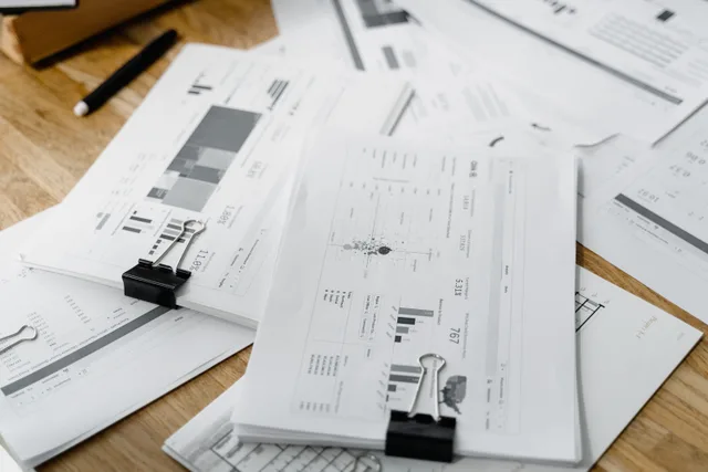 A stack of financial reports and graphs with clips on a wooden desk, highlighting business planning. Compliance trends: what network marketing programs cannot ignore