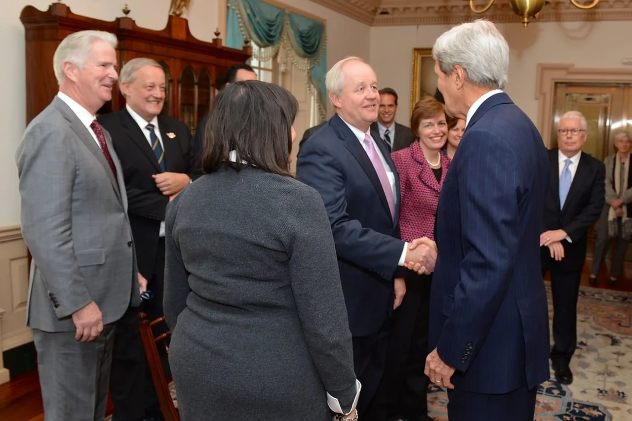 Business executives greet one another before a meeting.