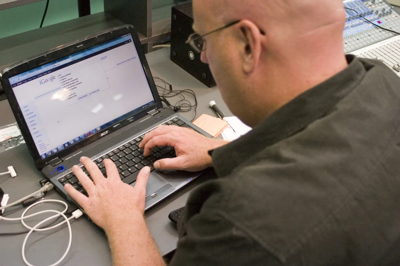 A person uses a laptop displaying a Google search page.